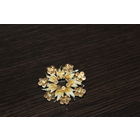 Металлическая брошь со стразами в виде цветка.