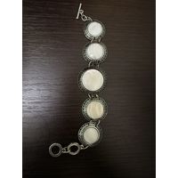 Браслет с вставками из белого перламутра в металлической оправе .