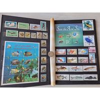 Альбом с марками - фауна морей и рек, рыбы, крабы, акулы, дельфины, киты, раки и др.